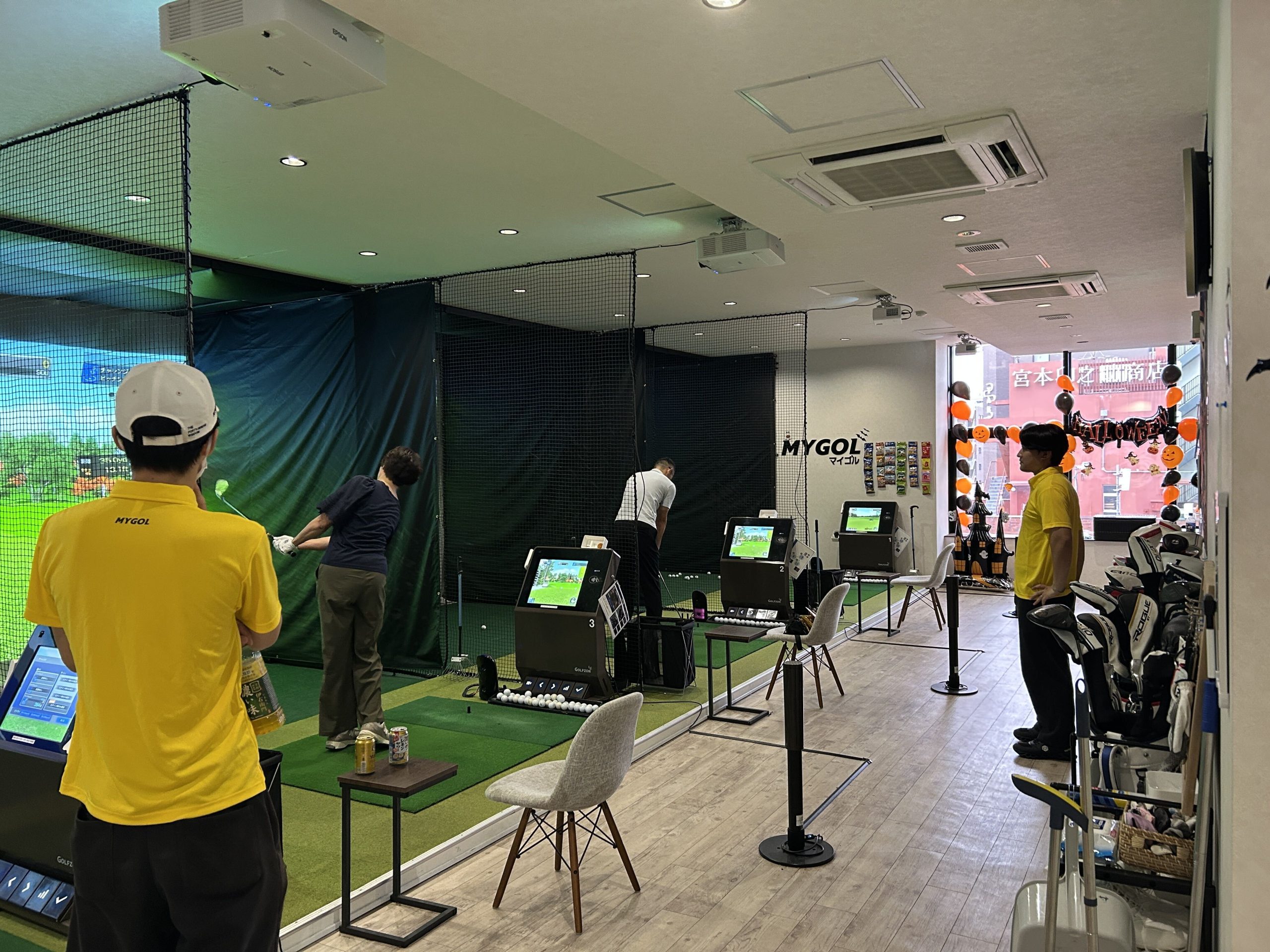 複数の打席で参加者がショットに取り組み、スタッフが見守る様子